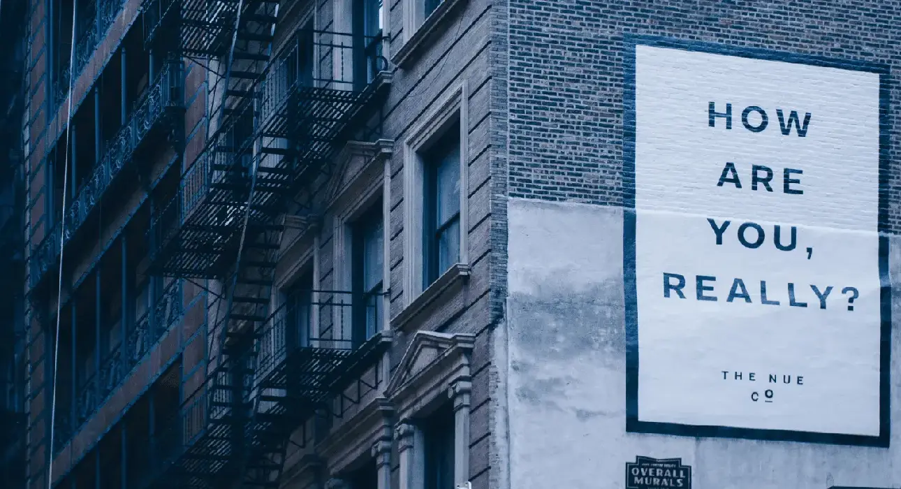 A building cast in blue light, with 'How Are You Really' on one of the walls