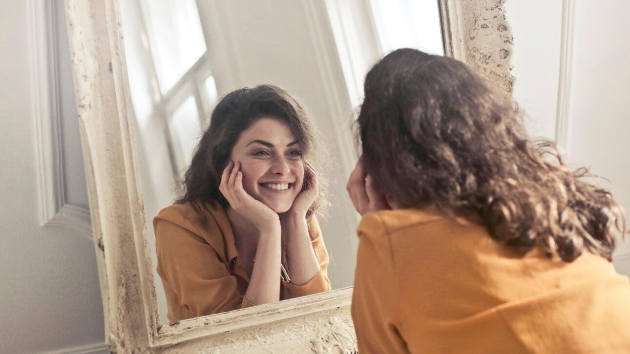 Woman smiling at herself in the mirror