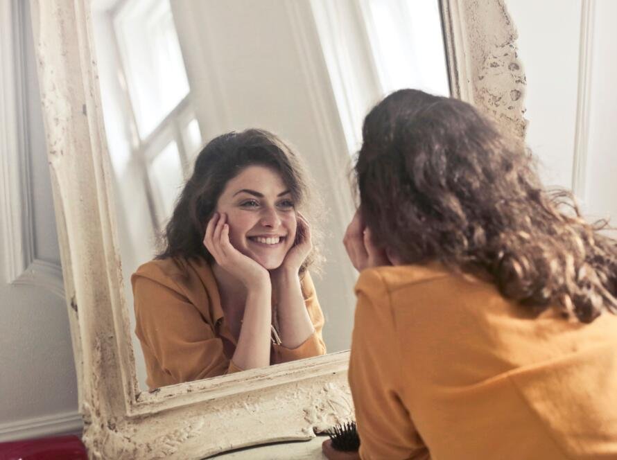 Woman smiling at herself in the mirror